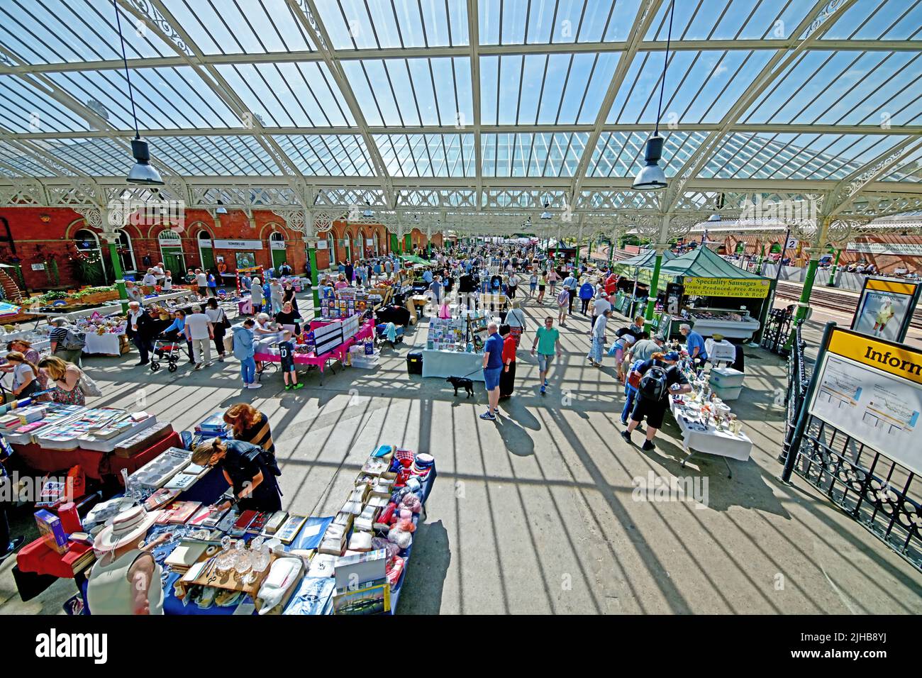 Il mercato delle pulci del fine settimana di Tynemouth mostra i supporti del tetto in vetro vittoriano di ghisa della stazione della metropolitana che getta le lunghe ombre in una giornata di sole Foto Stock