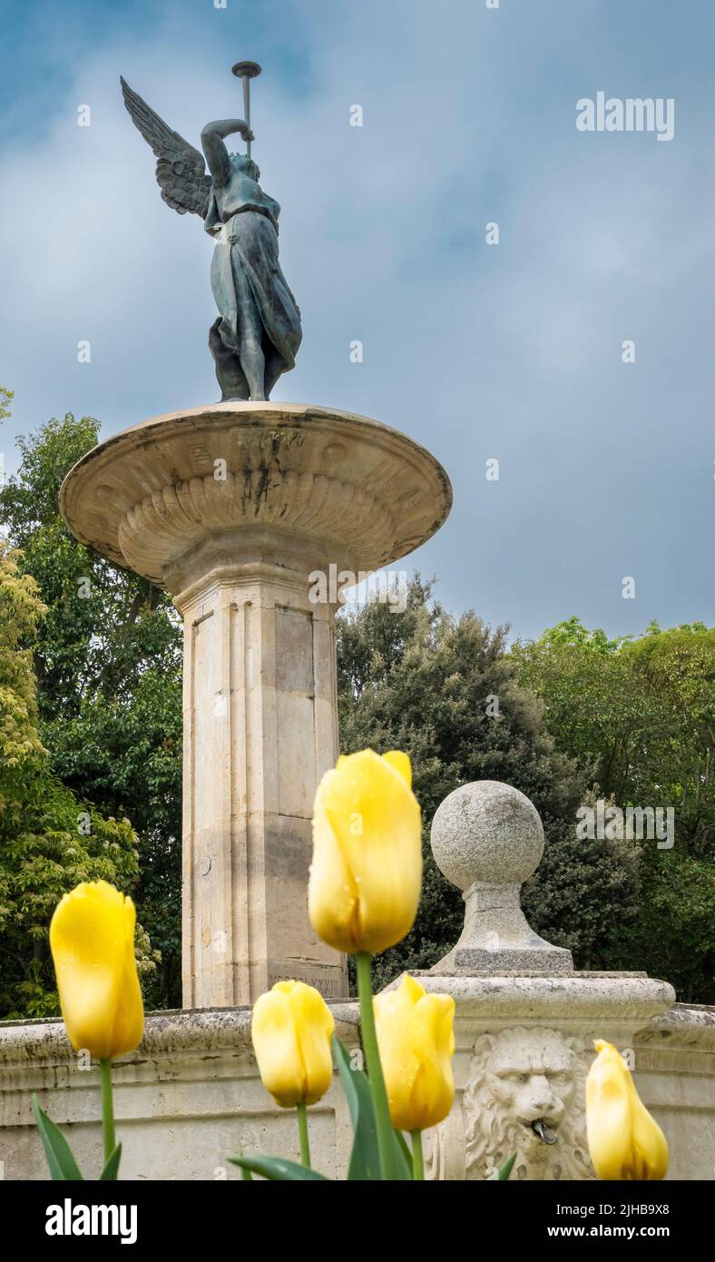 Una foto verticale della Fontana della Fame con tulipani nel campo Grande Park, Valladolid, Spagna Foto Stock