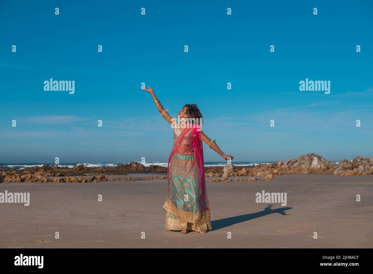Donna in abbigliamento indiano vista dalla spiaggia Foto Stock