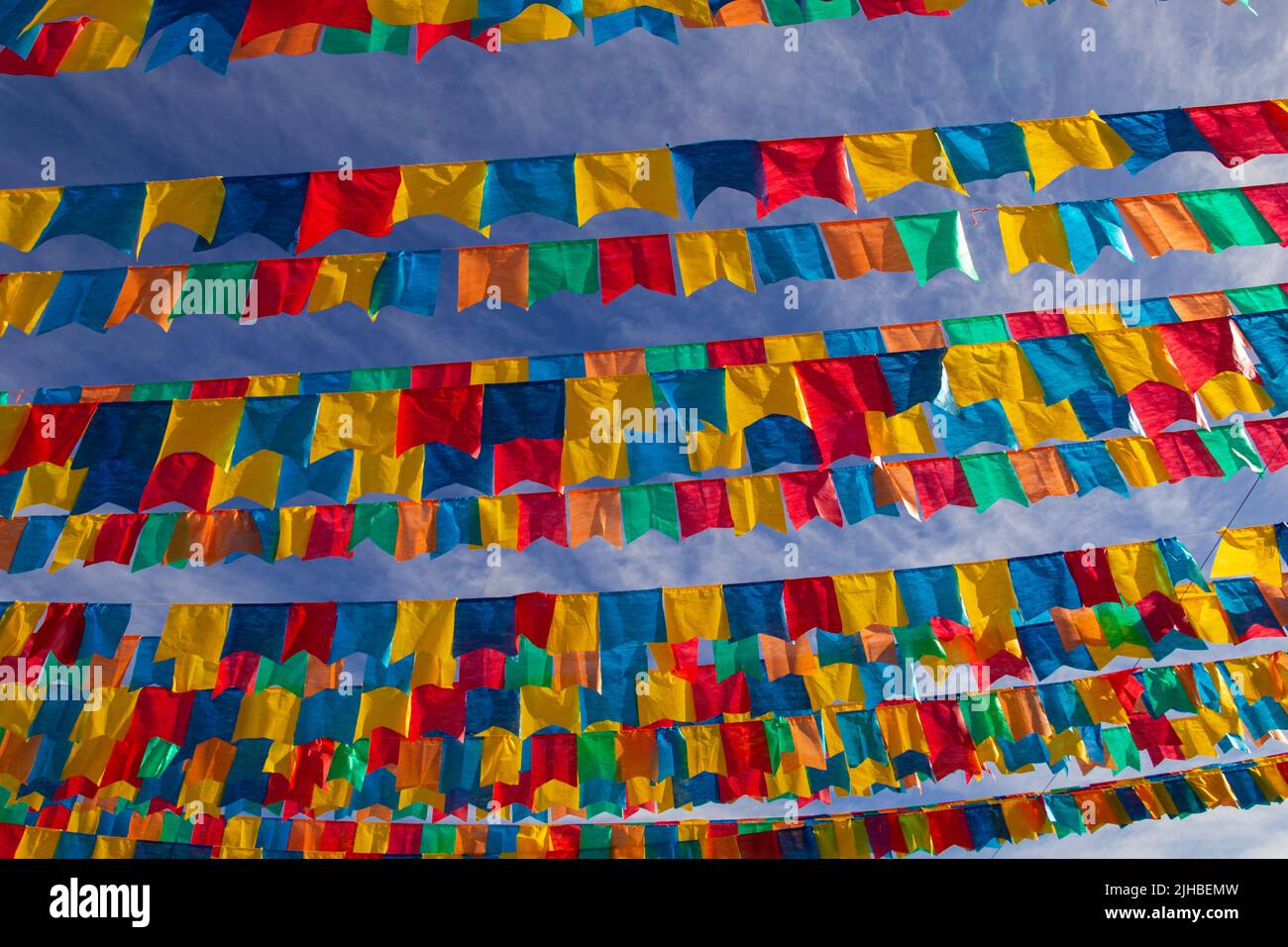 Goiania, Goiás, Brasile – 17 luglio 2022: Diverse linee di abbigliamento con bandiere di tessuto contro il cielo blu per la festa di giugno - tipico brasiliano 'Quadrilha' Foto Stock