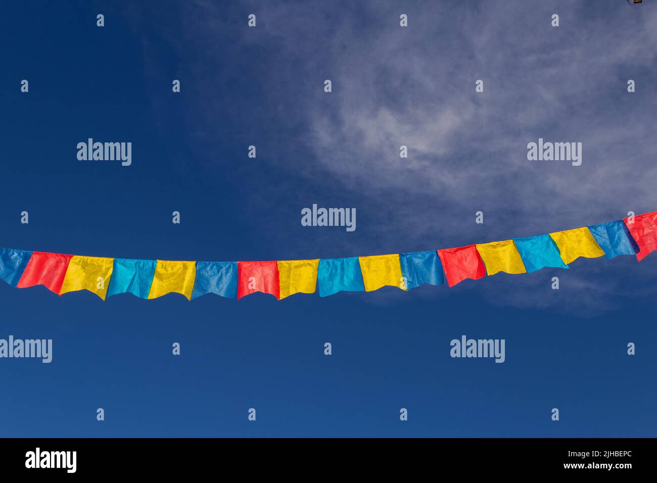 Goiania, Goiás, Brasile – 17 luglio 2022: Un clothesline con pennants tessuto contro il cielo blu per festa di giugno - tipico festival brasiliano. Quadrilha Foto Stock