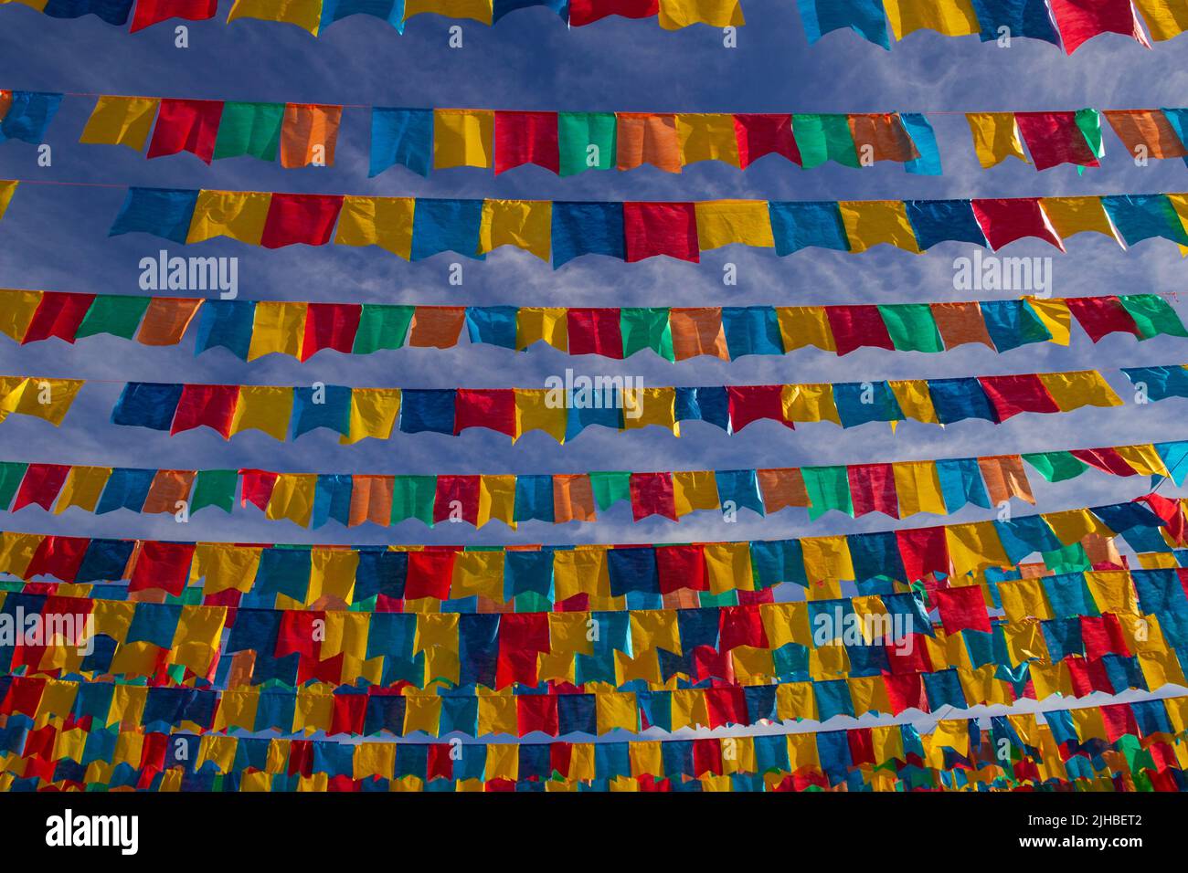 Goiania, Goiás, Brasile – 17 luglio 2022: Diverse linee di abbigliamento con bandiere di tessuto contro il cielo blu per la festa di giugno - tipico brasiliano 'Quadrilha' Foto Stock