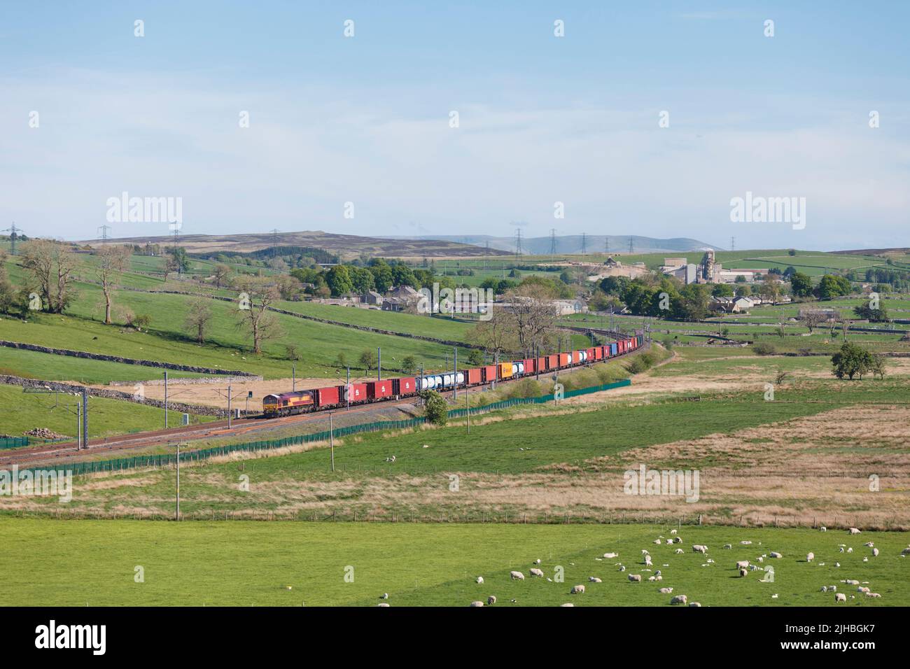 DB Cargo classe 66 locomotiva diesel sulla costa ovest mainline in Cumbria con un Seaforth Liverpool - Mossend contenitore intermodale treno merci Foto Stock