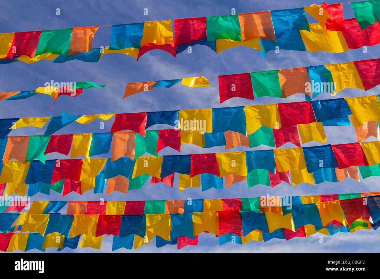 Goiania, Goiás, Brasile – 17 luglio 2022: Diverse linee di abbigliamento con bandiere di tessuto contro il cielo blu per la festa di giugno - tipico brasiliano 'Quadrilha' Foto Stock