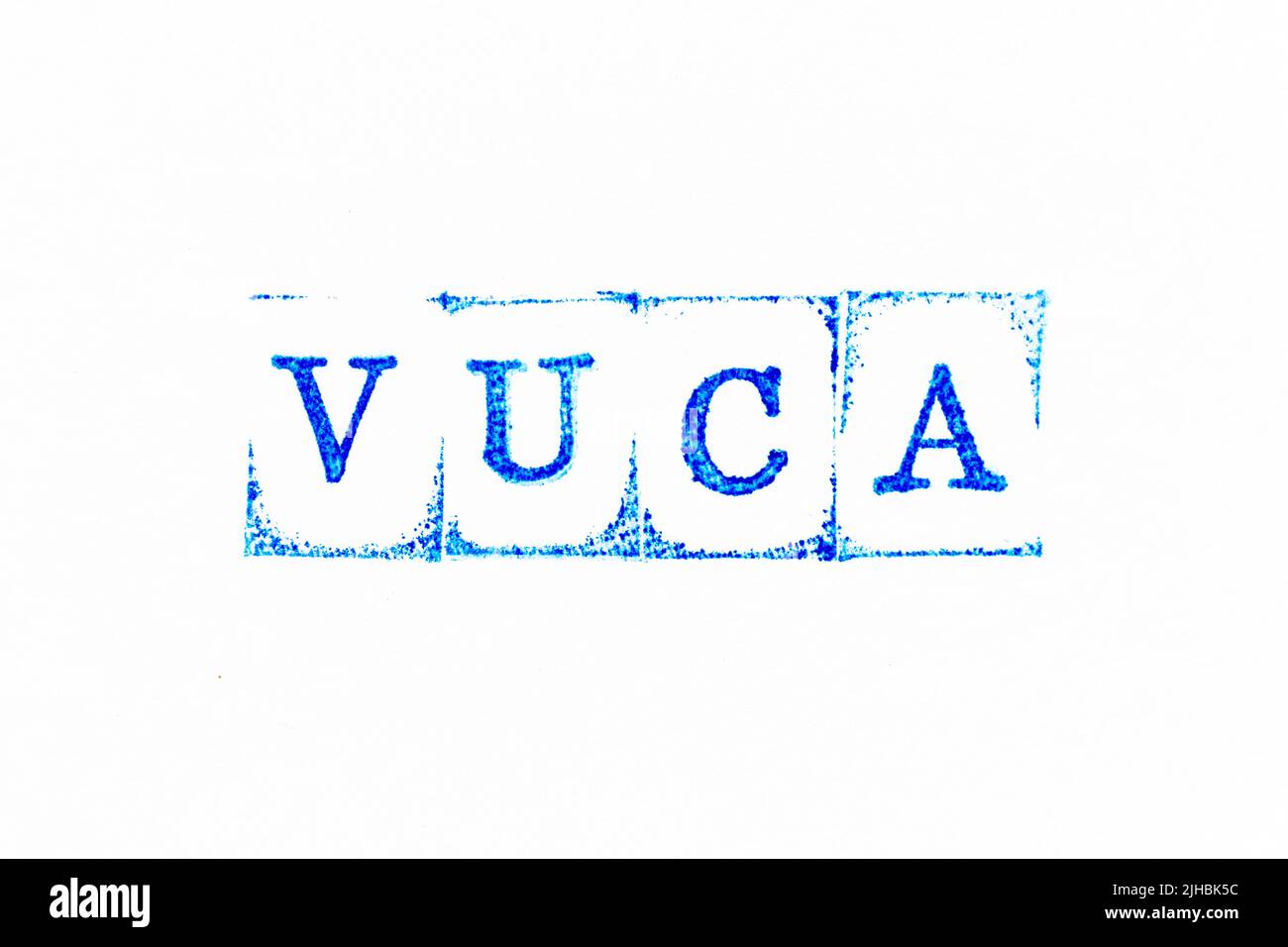 Timbro di gomma con inchiostro di colore blu in parola VUCA (abbreviazione di volatilità, incertezza, complessità e ambiguità) su sfondo di carta bianca Foto Stock