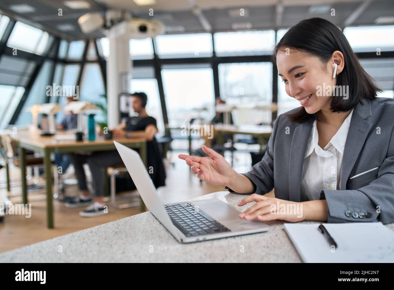 Giovane donna d'affari asiatica felice che usa le conferenze del laptop in ufficio. Foto Stock
