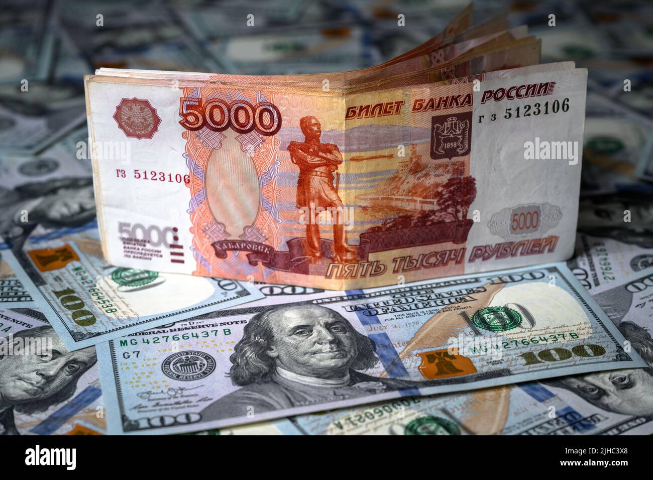 Il denaro rublo russo contro il dollaro americano, la banconota rublo è in cima al cumulo di bollette in dollari. Concetto di sanzioni, valuta, vittoria del rublo, economia della Russia A. Foto Stock