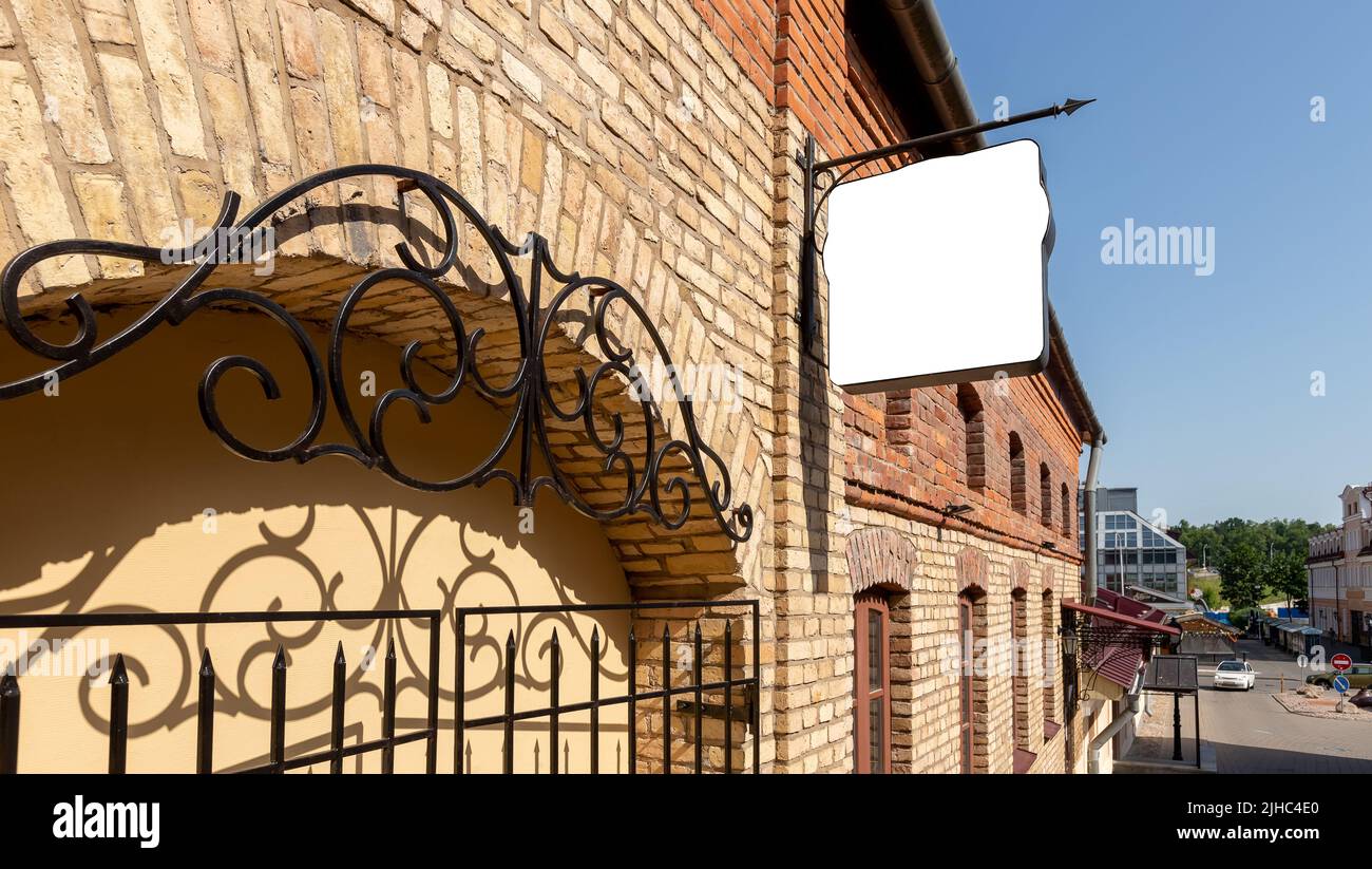 Cartello quadrato mockup nel vecchio edificio in mattoni della città. Bordo per esporre caffè, ristorante, negozio, museo, hotel, nome o logo aziendale. Poster pubblicitario all'aperto. Foto di alta qualità Foto Stock