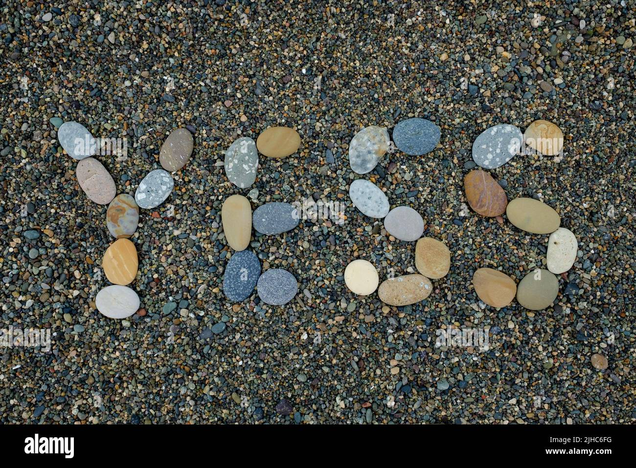 Parola yess fatto di pietre su spiaggia sabbiosa, Foto Stock