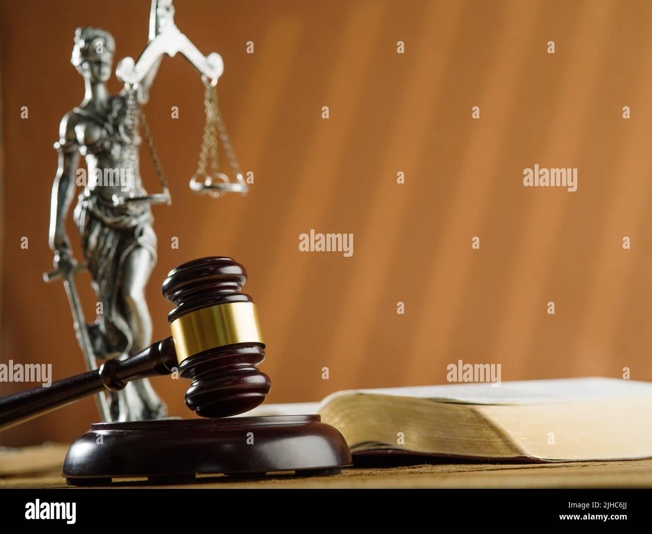 Primo piano. Un gavel di legno di un giudice, una statuetta di bronzo della dea della giustizia - Themis e un libro aperto su sfondo beige. Lo Stato di diritto. Jud Foto Stock