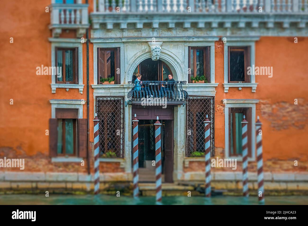 Una coppia sta gustando il pranzo su un piccolo balcone sul canale Grande a Venezia, Italia Foto Stock