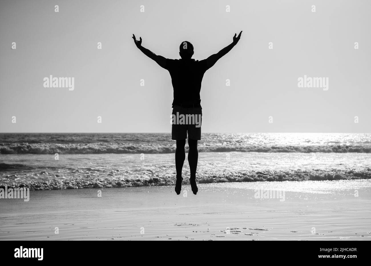 sentitevi liberi. giovani e liberi. atleta sportivo che salta nell'oceano. attività di allenamento mattutina. Foto Stock