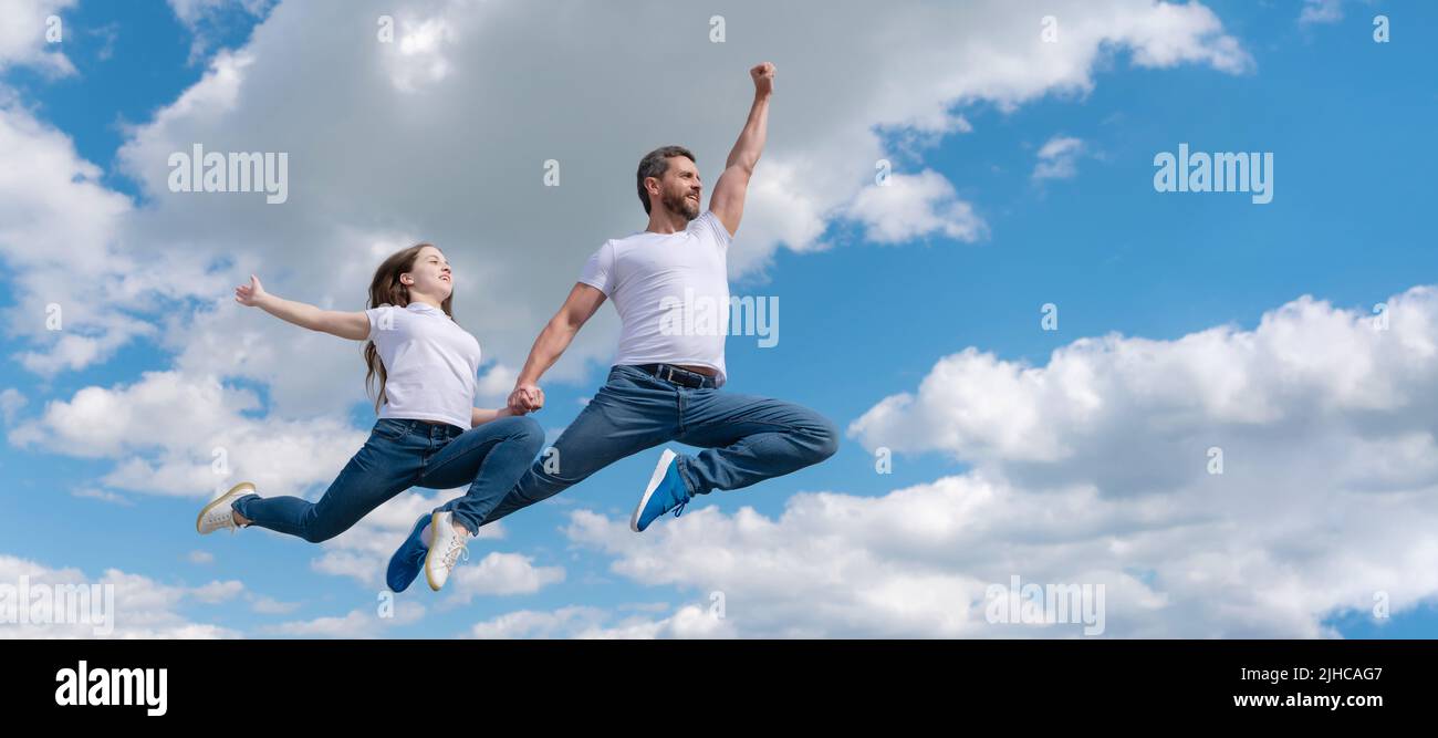 Padre e figlia saltano sul cielo, bandiera con spazio copia. Papà felice e figlia saltano nel cielo. Giorno della famiglia Foto Stock