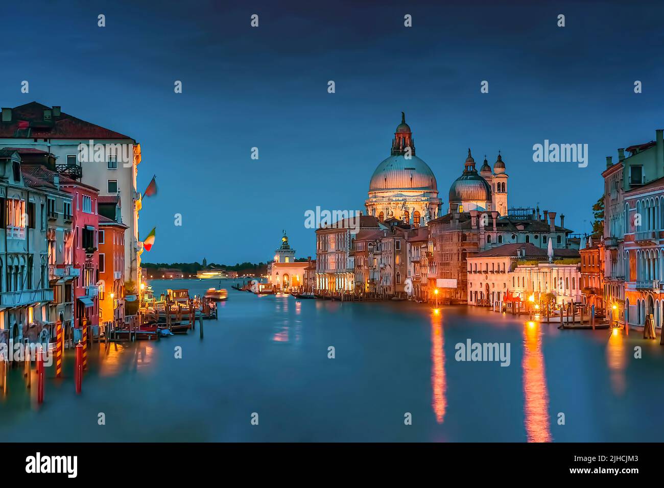 Il Canal Grande di Venezia, con la famosa Basilica di Santa Maria della Salute sullo sfondo durante l'ora Blu Foto Stock