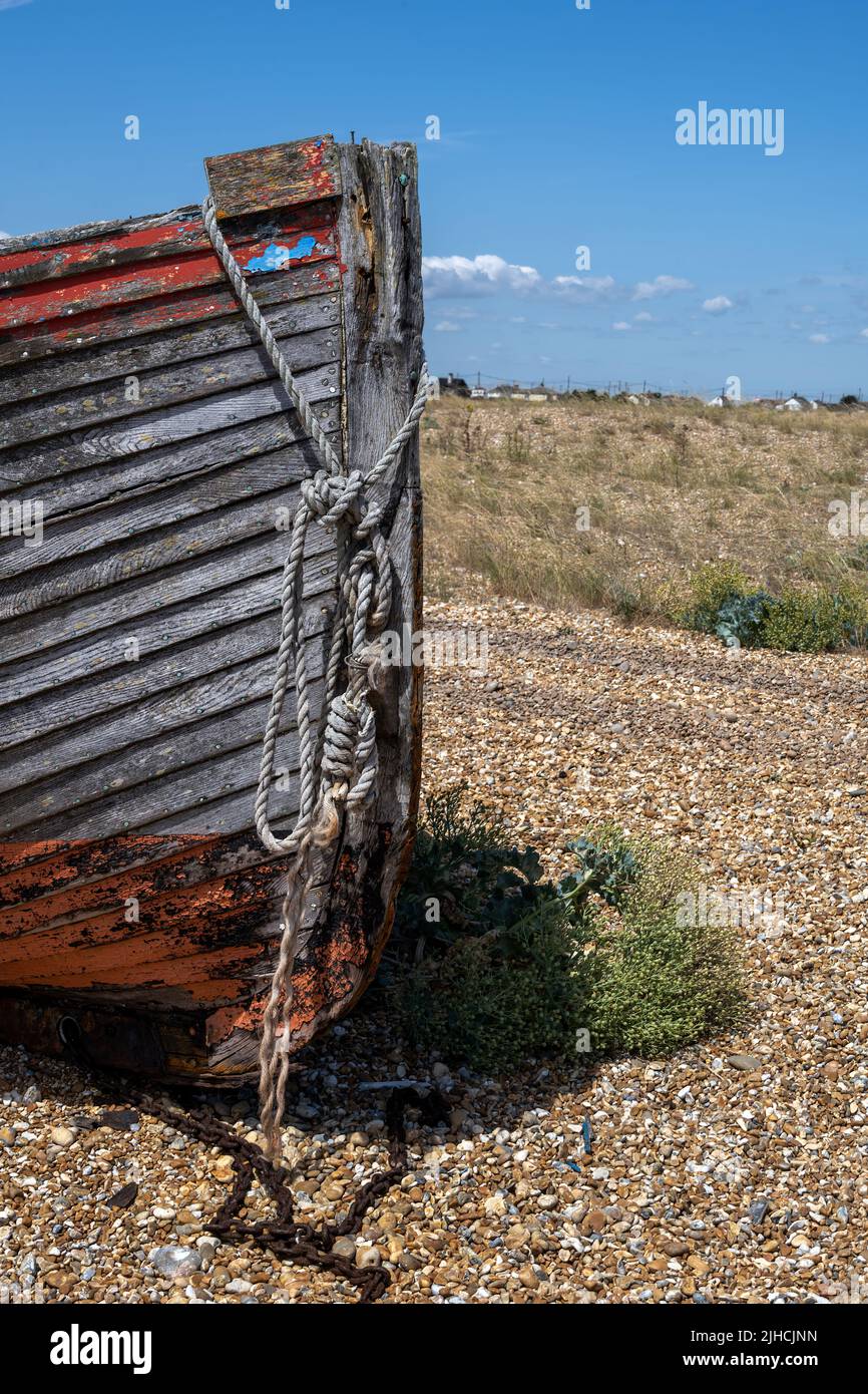 Prua di una vecchia barca di legno sulla spiaggia di ghiaia di Dungeness, Kent, Inghilterra Foto Stock