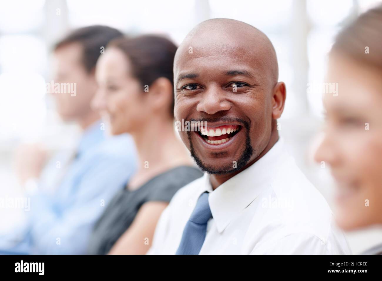 Raggiungerò - motivazione di affari. Bell'uomo d'affari afro-americano vi dà un grande sorriso mentre partecipate ad una conferenza. Foto Stock