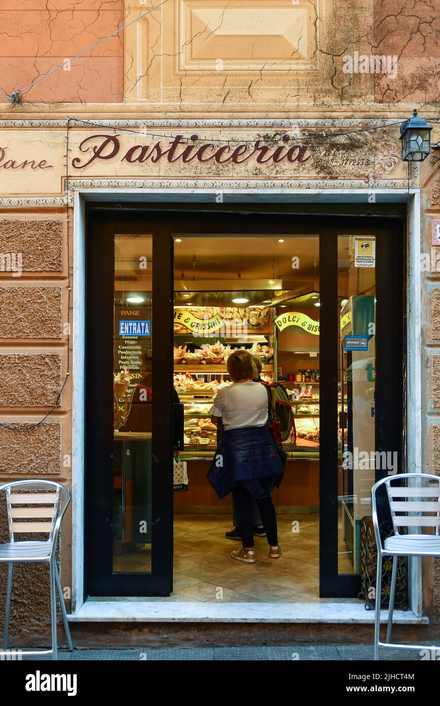 L'ingresso di una tipica panetteria-pasticceria con gente che si allaccia al bancone nel centro storico di Rapallo, Genova, Liguria, Italia Foto Stock
