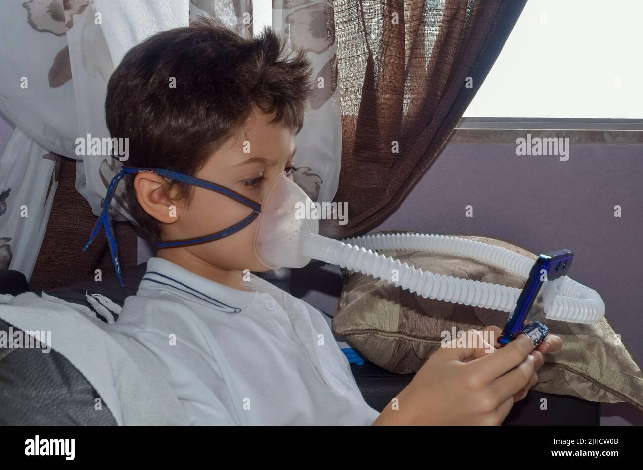 Bambino con maschera di appannamento sul suo viso gioco. Salvador, Bahia, Brasile. Foto Stock