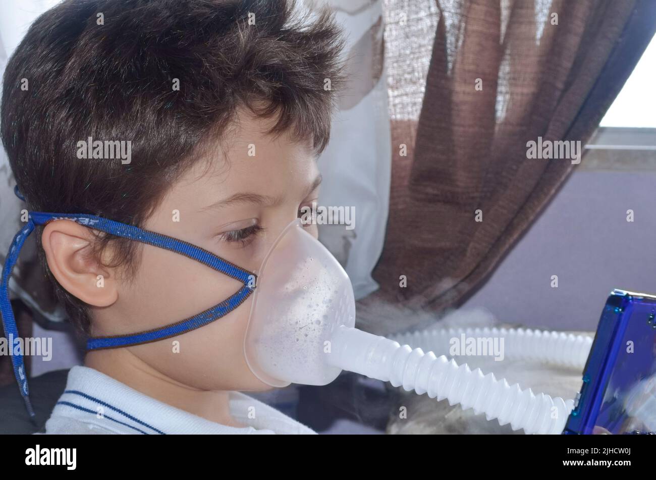 Bambino con maschera di appannamento sul suo viso gioco. Salvador, Bahia, Brasile. Foto Stock