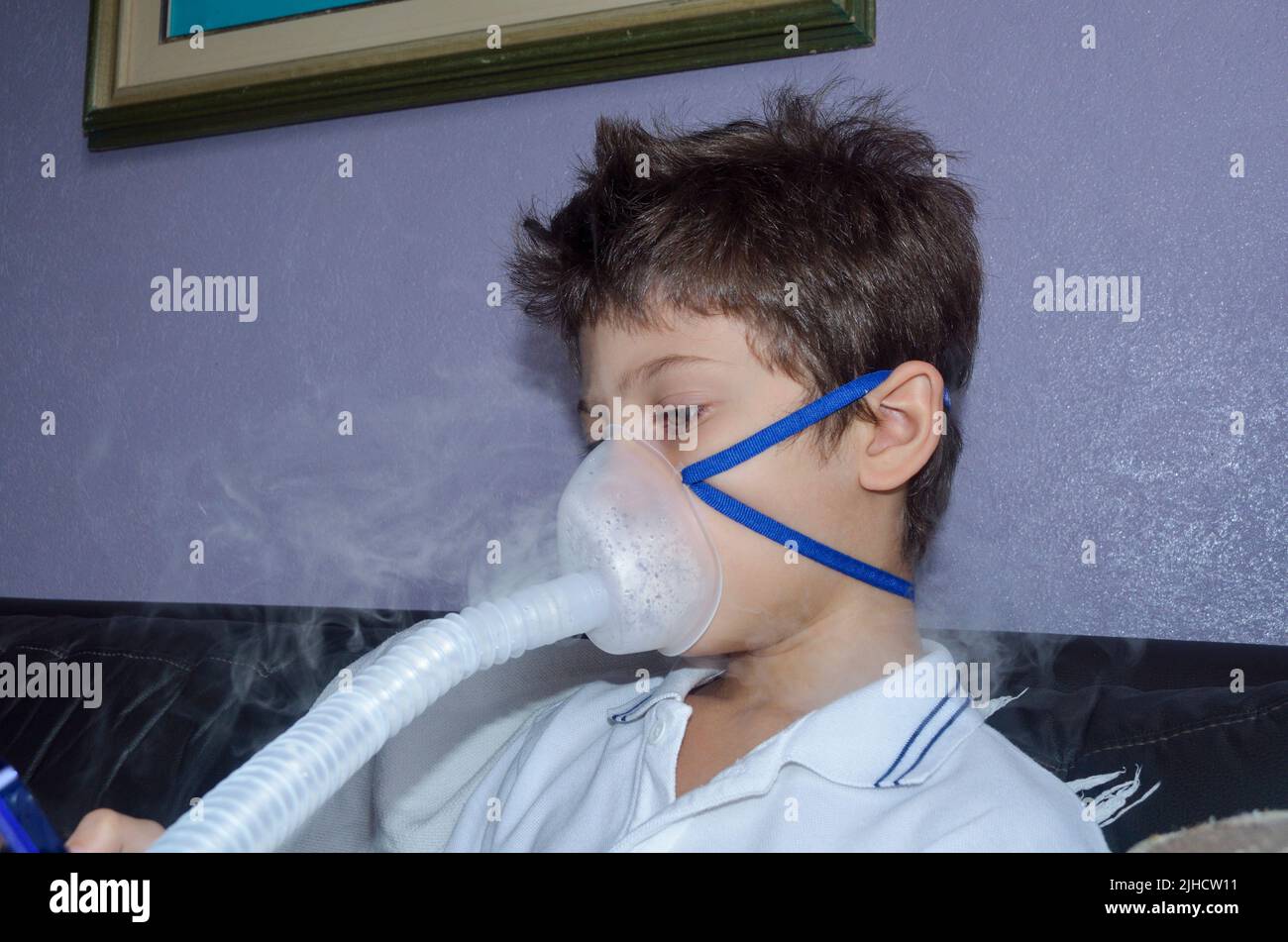 Bambino con maschera di appannamento sul suo viso gioco. Salvador, Bahia, Brasile. Foto Stock