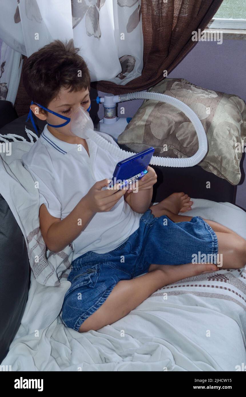 Bambino con maschera di appannamento sul suo viso gioco. Salvador, Bahia, Brasile. Foto Stock