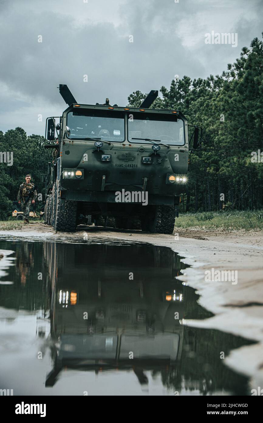 Un autocarro tattico con mobilità estesa pesante trasporta una terna 420E in un'area di addestramento locale durante Summer Pioneer 2022 a Camp Lejeune, North Carolina, 16 luglio 2022. Summer Pioneer 2022 è un esercizio di ingegneria navale che dimostra l'integrazione del corpo Marino degli Stati Uniti e delle formazioni della Marina degli Stati Uniti per stabilire e sostenere le basi avanzate di Expeditionary (EAB) e la consapevolezza del dominio marittimo. (STATI UNITI Foto del corpo marino di Lance CPL. Meshaq Hylton) Foto Stock