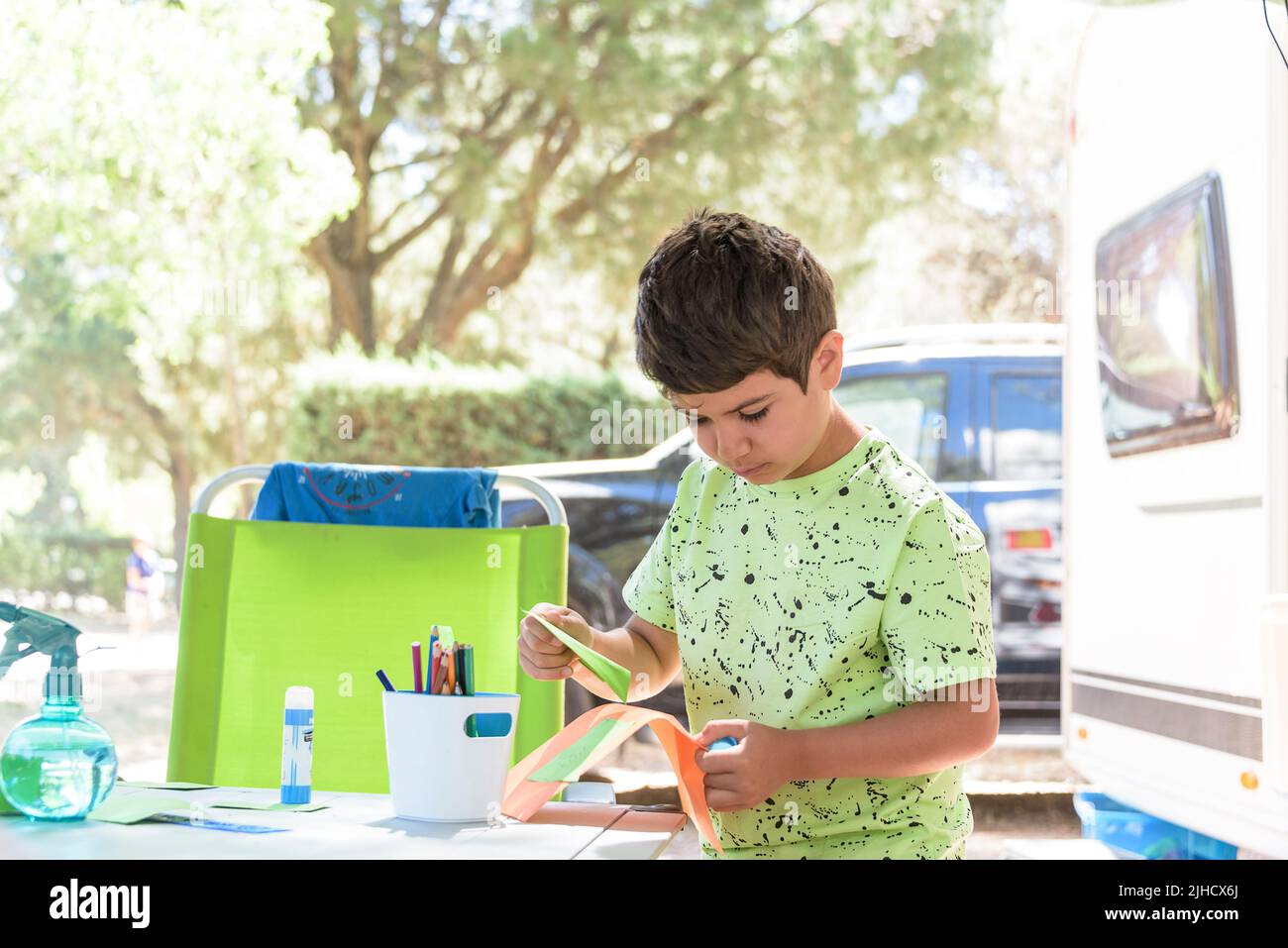 Ragazzo della scuola elementare che fa lavoro manuale mentre è in vacanza e si prepara a tornare a scuola. Foto Stock