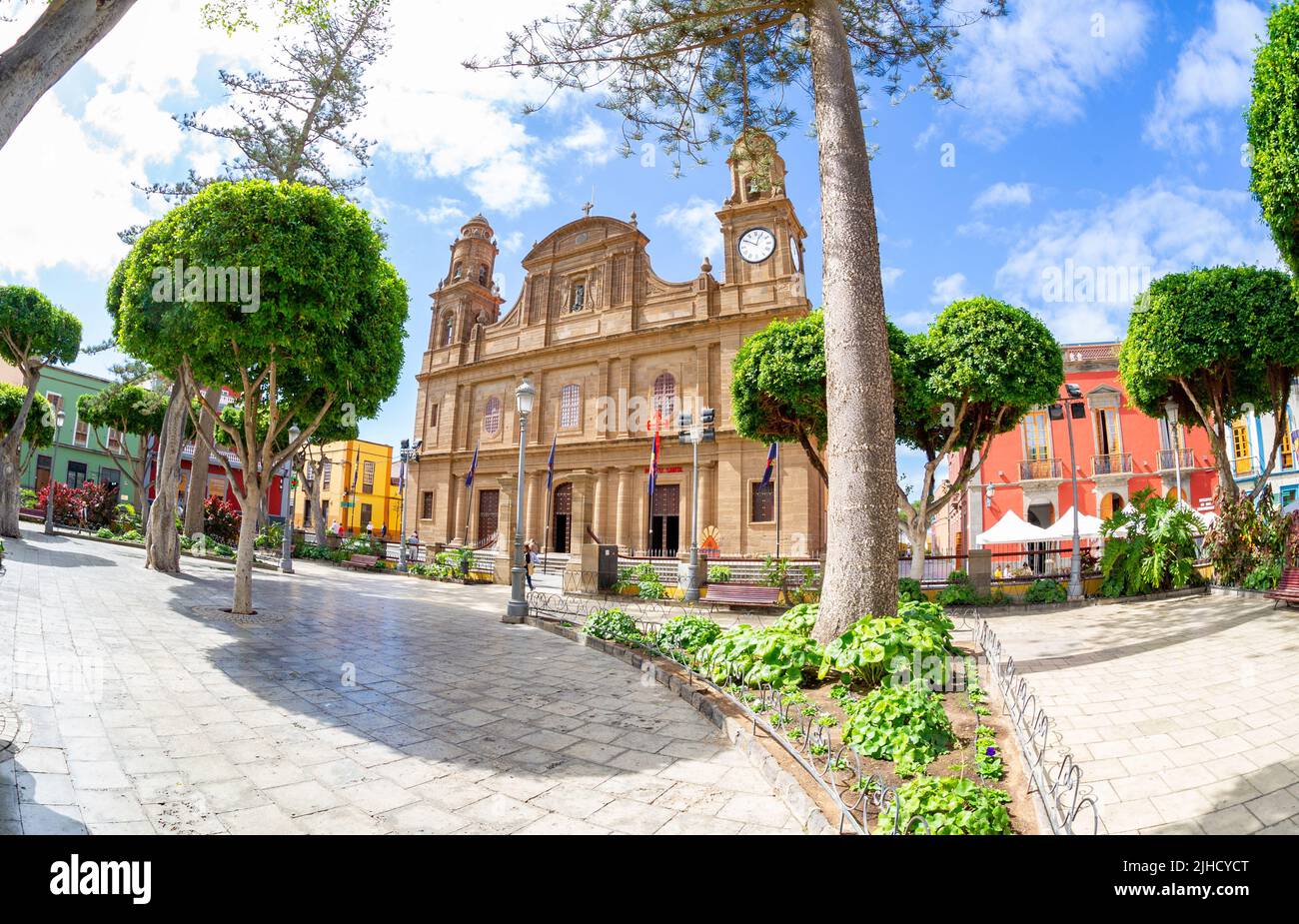 Febbraio 20 2022-Galdar, Spagna : Centro storico in tempo di sole, con vecchia chiesa e palme verdi, bella fontana di fronte Foto Stock