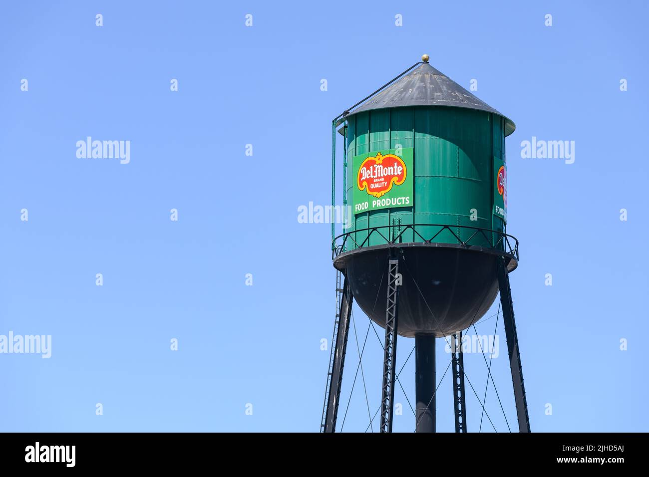 Yakima, WA, USA - 11 luglio 2022; torre d'acqua verde tradizionale con cartello per del Monte Brand Quality Food Products contro un cielo blu Foto Stock