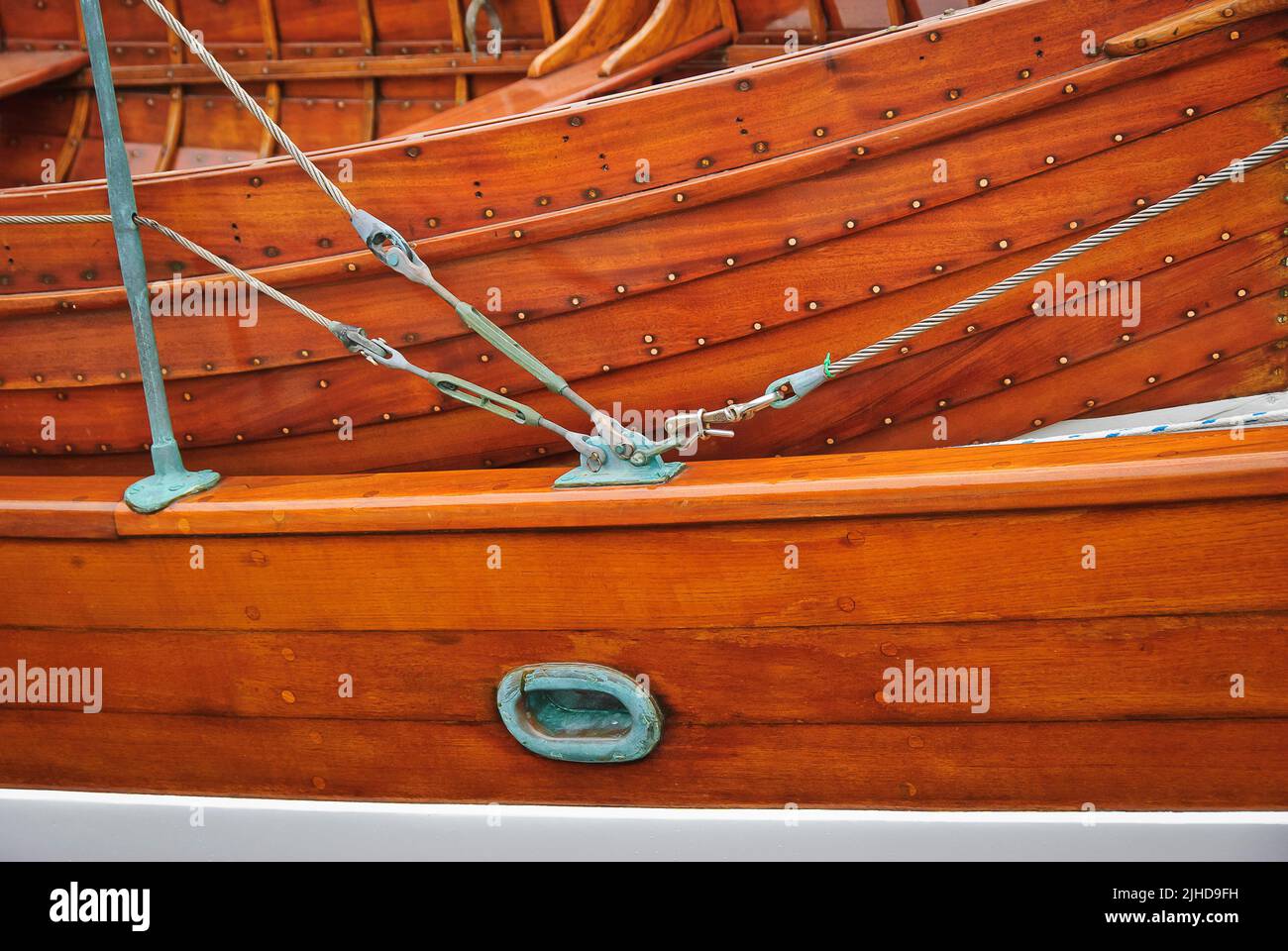 Lapstrake dinghy sul ponte fissato dietro l'abbinamento in legno lapstrake coaming della nave madre. Foto Stock