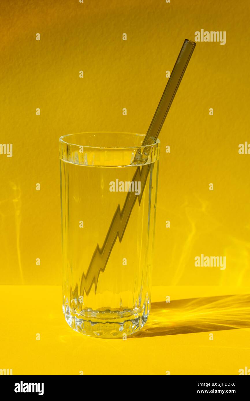 Cannucce in vetro riutilizzabili con acqua su sfondo giallo Set di cannucce per bevande ecologico con spazzola per la pulizia. Concetto senza rifiuti, senza plastica. Stile di vita sostenibile. Soggiorno senza rifiuti bassa rifiuti Foto Stock