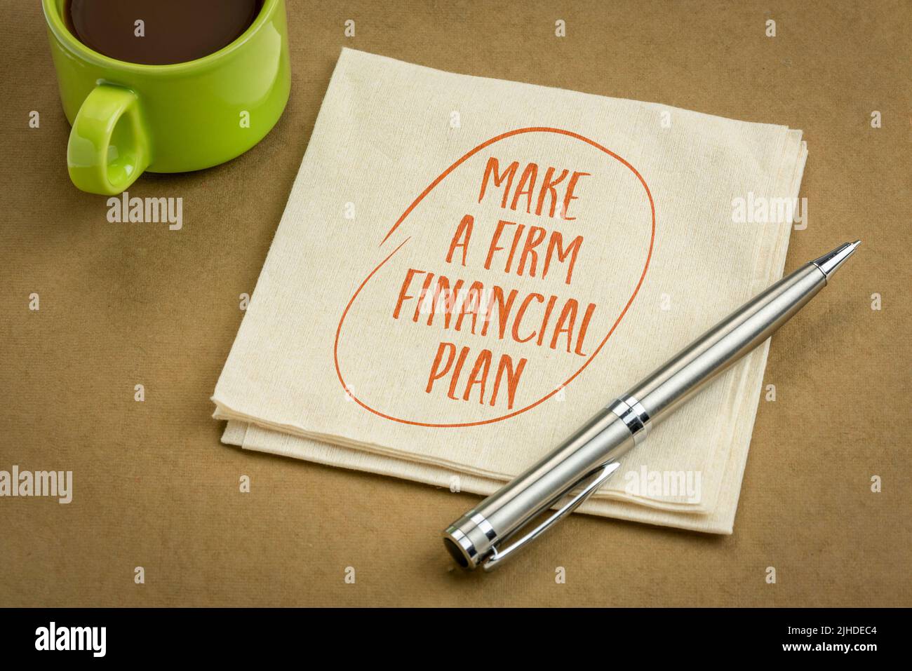 faccia un piano finanziario fermo - consiglio motivazionale o promemoria, scrivendo su tovagliolo con caffè Foto Stock