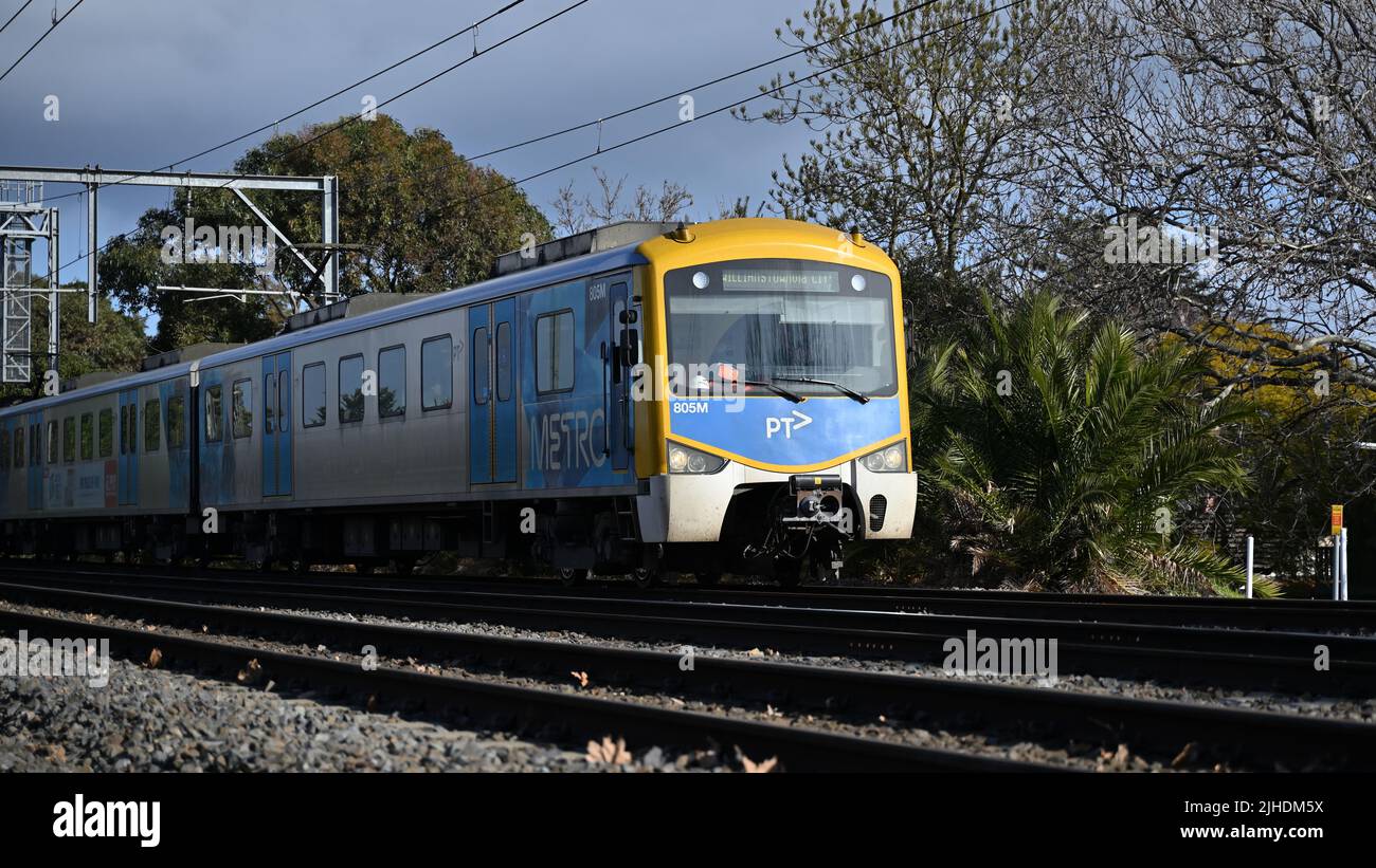 Treno giallo e blu Siemens Nexas, che si dirige verso Williamstown attraverso il centro di Melbourne, caratterizzato dal marchio attuale PTV e Metro Foto Stock