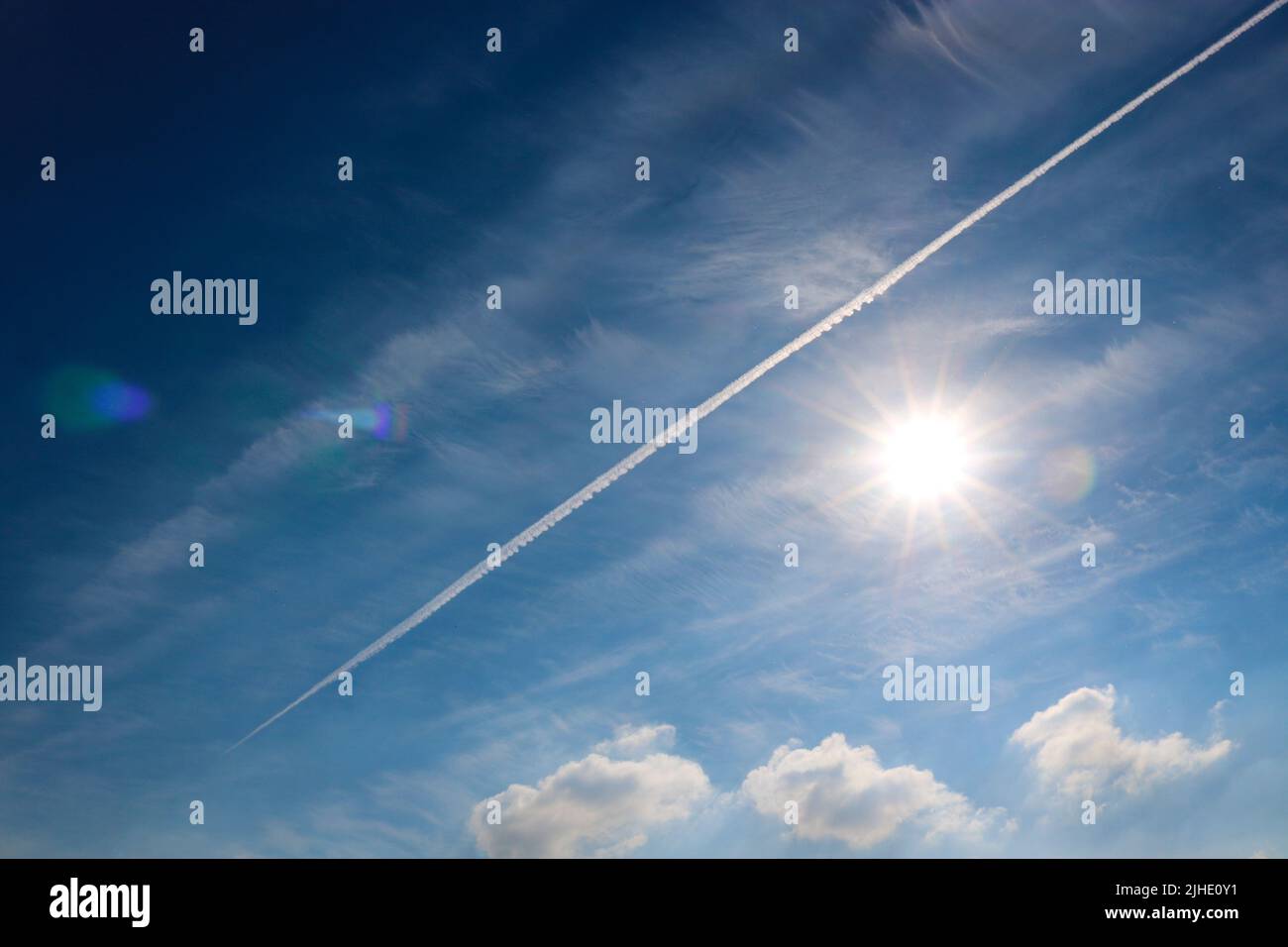 Il cielo blu e il sole, la traccia dell'aereo Foto Stock