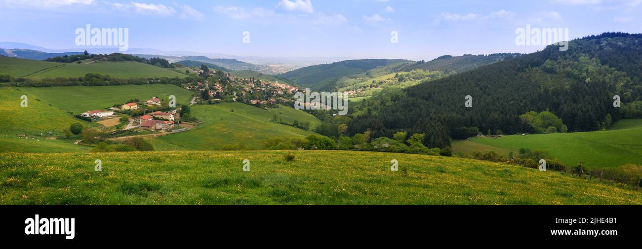 Tipico villaggio nella campagna francese in primavera con erba verde e colline naturali Foto Stock