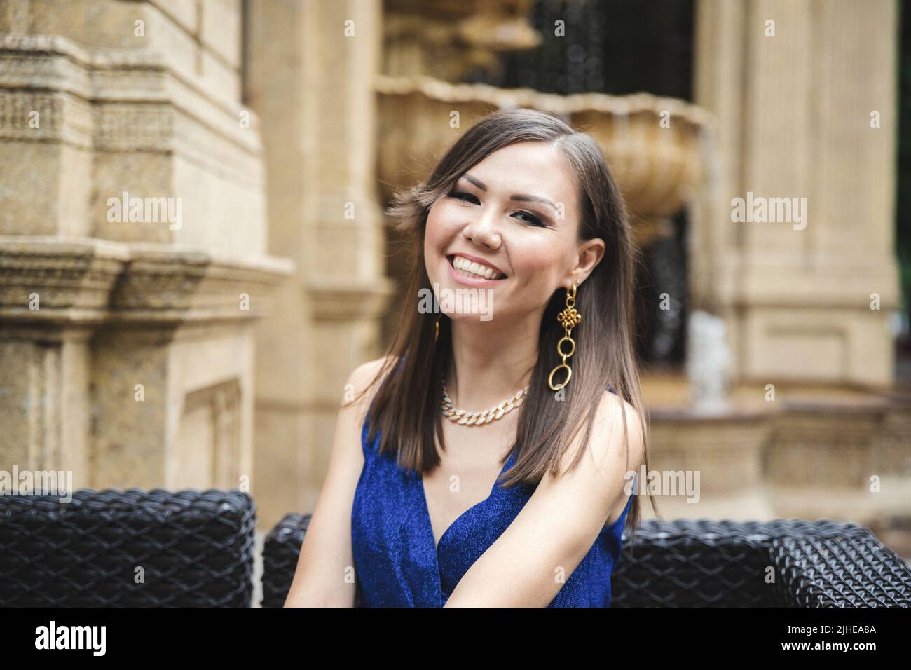 Donna asiatica piuttosto sorridente in abito blu ritratto esterno Foto Stock