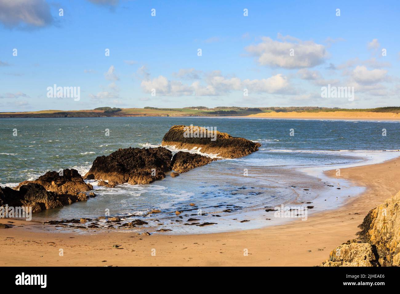 Piccola baia e vista sulla baia di Malltraeth e sulla spiaggia dalla riserva naturale nazionale di Ynys Llanddwyn Island, Newborough, Isle of Anglesey, North Wales, UK Foto Stock