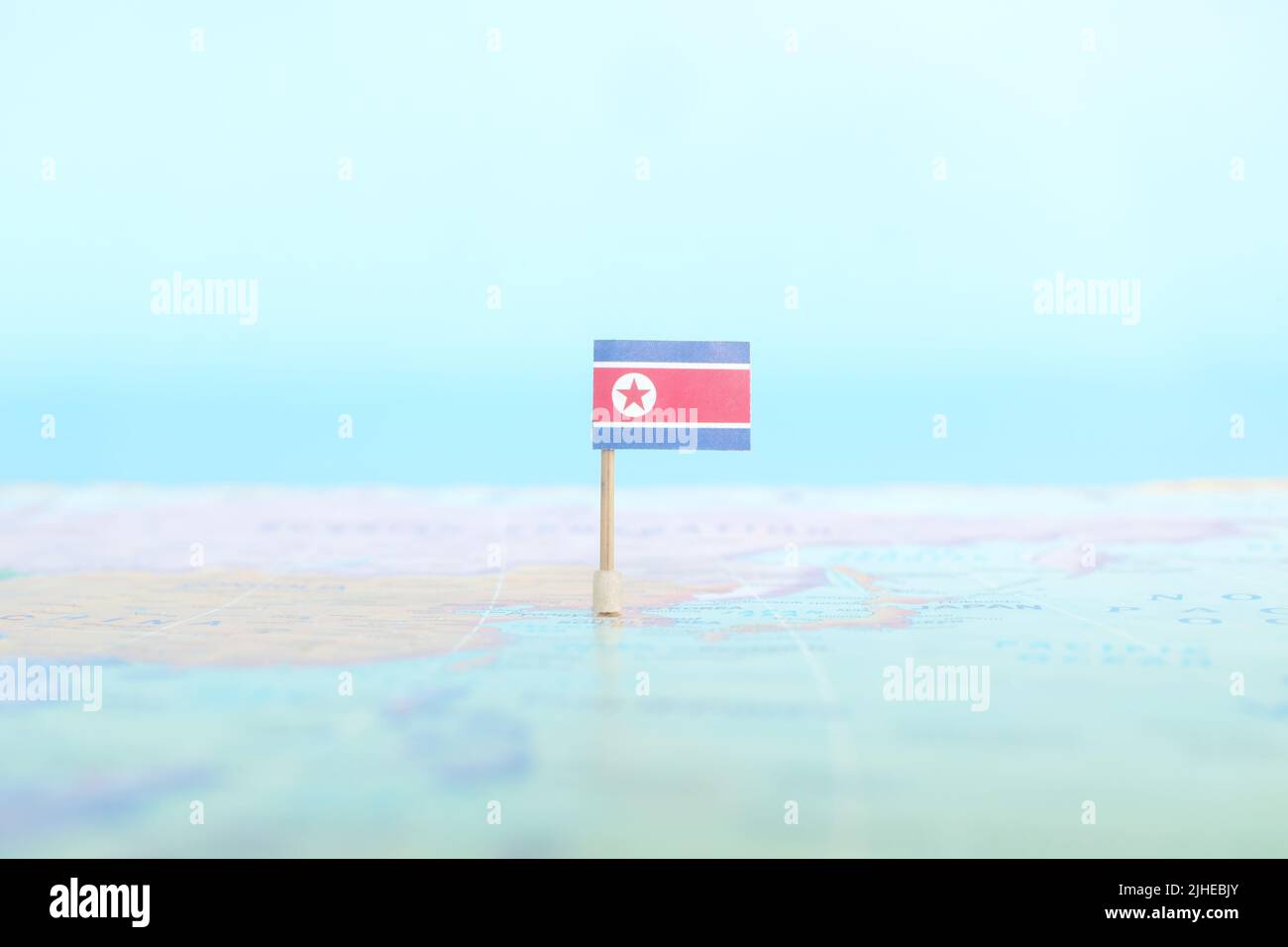 Fuoco selettivo della bandiera nordcoreana nella mappa del mondo. Concetto di posizione e sovranità del paese della Corea del Nord. Foto Stock