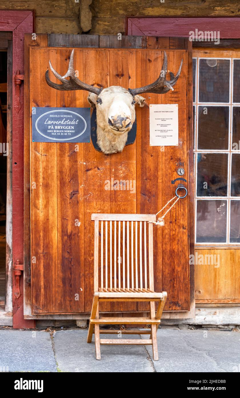 Bergen Norvegia, testa di alce ornamentali contro porta di legno con sdraio per i turisti di fare la loro foto sotto la testa di alce Foto Stock