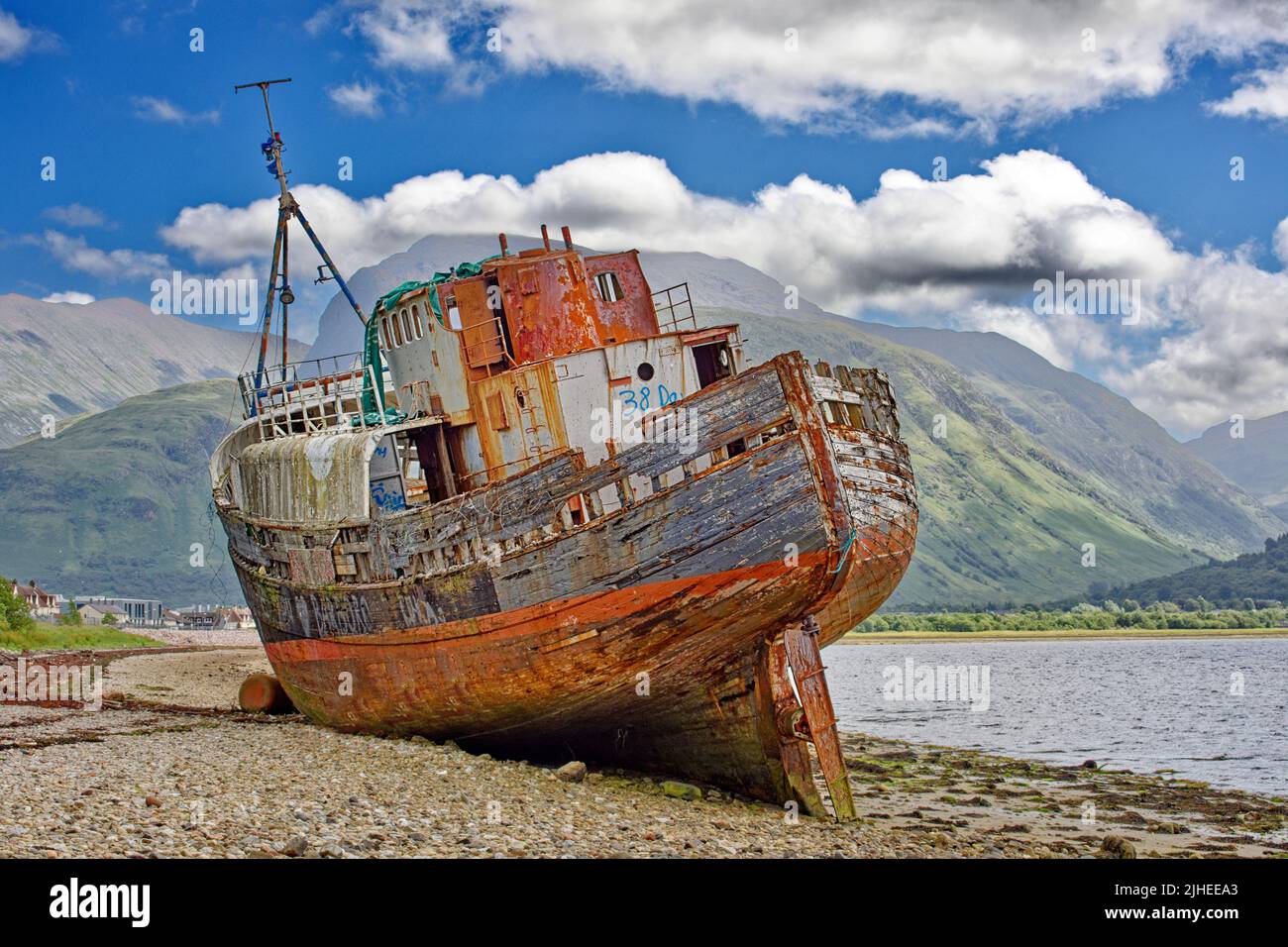 VECCHIA BARCA DI CAOL FORT WILLIAM SCOZIA UNA BARCA COLORATA SULLA SPIAGGIA DI CAOL E BEN NEVIS IN ESTATE Foto Stock