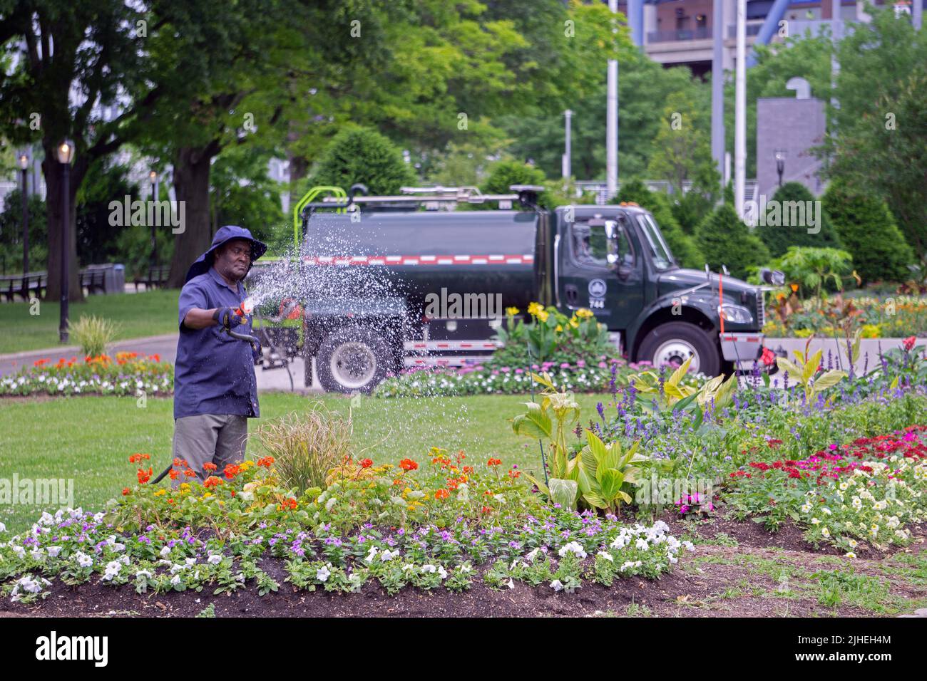 Un operaio del Dipartimento dei Parchi di New York maneggia un letto di fiori in Flushing Meadows Corona Park in Queens, New York City. Foto Stock