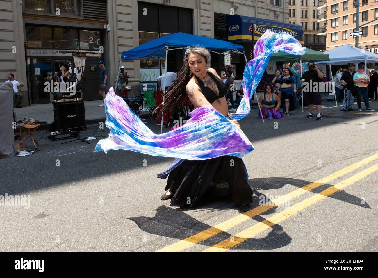 Una ballerina del ventre balla mentre ondita i tessuti colorati. Al Witchsfest 2022 su Astor Place nell'East Village, Manhattan, New York City. Foto Stock