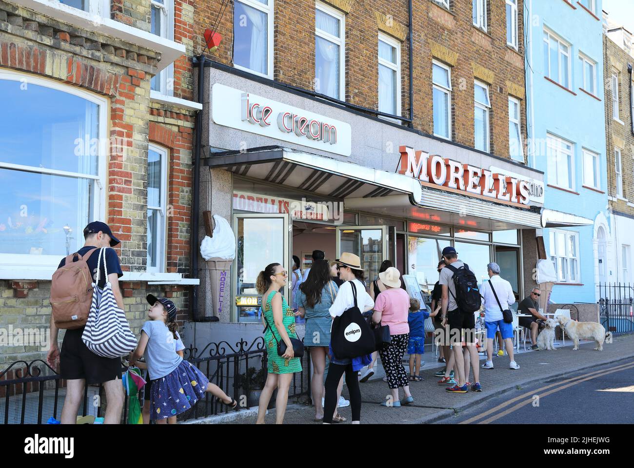 Lunghe code nella stagione calda per il gelato al famoso Morellis, la gelateria che ha aperto nel 1932, sul lungomare di Broadstairs, sopra Viking Bay, mentre la folla si è affollata al mare, nel Kent, Regno Unito Foto Stock