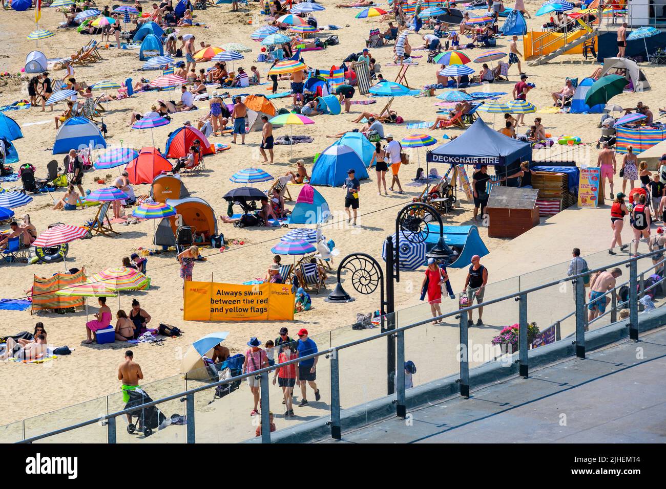 Lyme Regis, Dorset, Regno Unito. 18th luglio 2022. UK Meteo: La spiaggia alla pittoresca località balneare di Lyme Regis è stata occupata da mezzogiorno come gli amanti del sole crogiolavano nel caldo e blisteringly caldo sole onda sul 'primo lunedì'. Le temperature sono impostate per raggiungere i massimi senza precedenti in 40°s in alcune parti del Regno Unito oggi ed un avvertimento rosso di Met Office per "calore estremo" è in atto. Nonostante gli avvertimenti, oggi la gente si stava godendo felicemente del sole. Credit: Celia McMahon/Alamy Live News Foto Stock