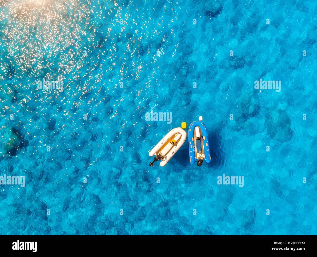 Vista aerea delle barche in acque blu limpide al tramonto in estate Foto Stock