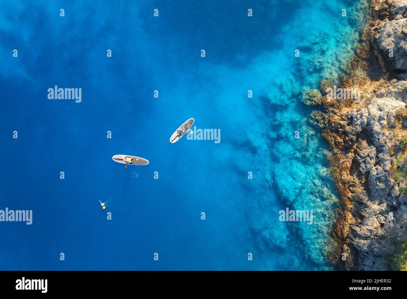 Vista aerea di persone su tavole sup galleggianti sul mare blu Foto Stock