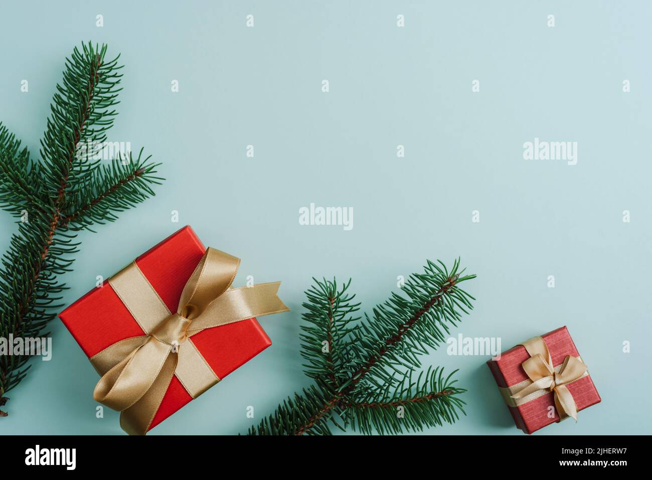 Natale sfondo festivo. Scatole regalo e rami di abete su sfondo verde chiaro. Vista dall'alto, disposizione piatta, spazio di copia. Foto Stock