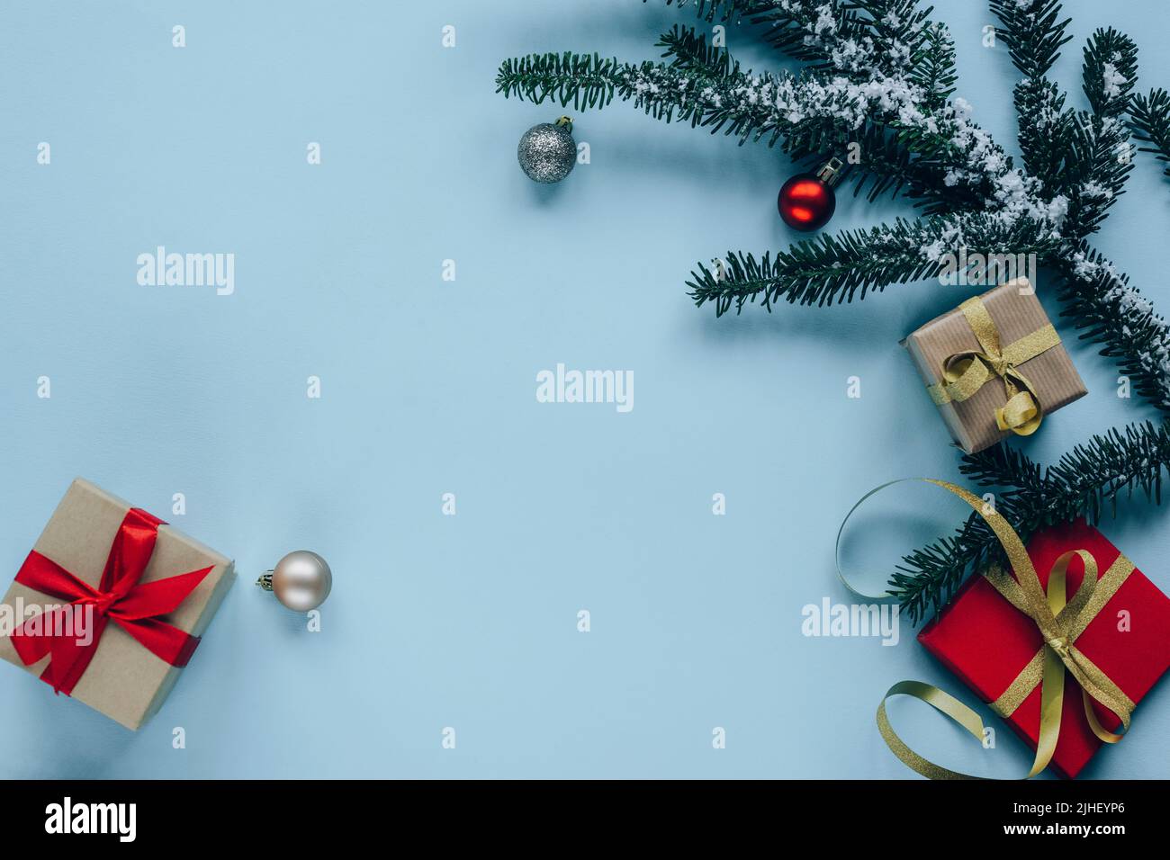 Decorazioni natalizie, scatole regalo, rami di abete, baubles su sfondo azzurro. Vista dall'alto, disposizione piatta, spazio di copia. Foto Stock