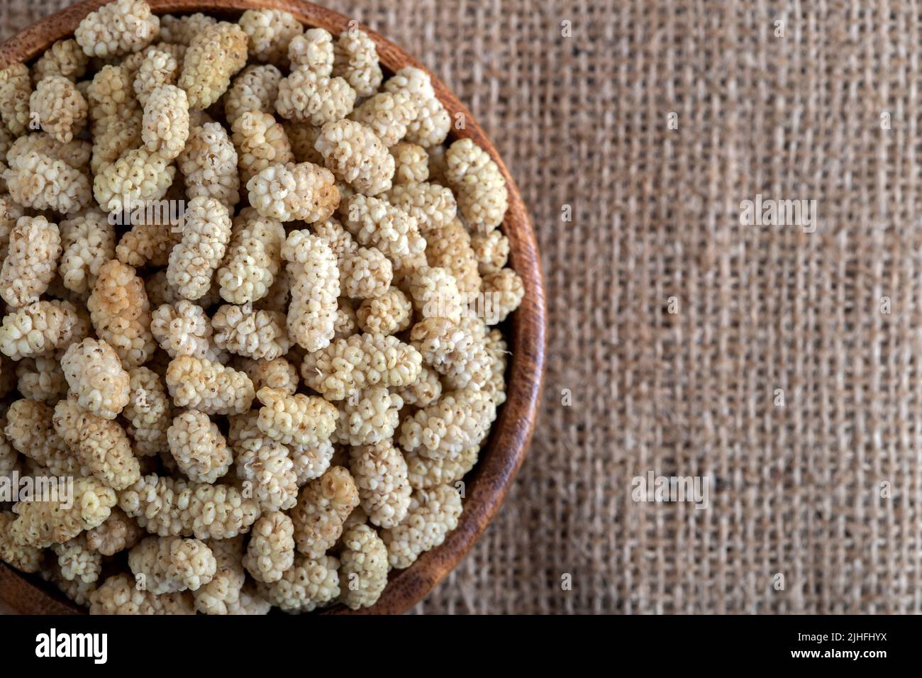 Ciotola piena di gelso secco su uno sfondo di tessuto Foto Stock