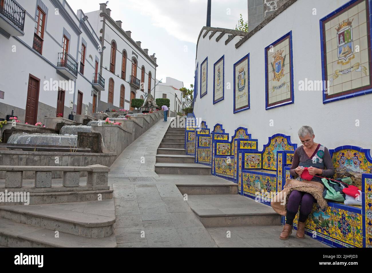 Passeggiata Paseo de Canarias con piastrelle in ceramica, donna delle canarie seduta su panca e maglie artful, Firgas, Grand Canary, Isole Canarie, Spagna, Europa Foto Stock